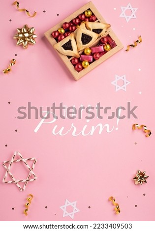 Purim celebration jewish carnival holiday card. Tasty homemade hamantaschen cookies, red carnival mask, noisemaker, sweet candies and party decor on pink background. Top view. Happy Purim concept.