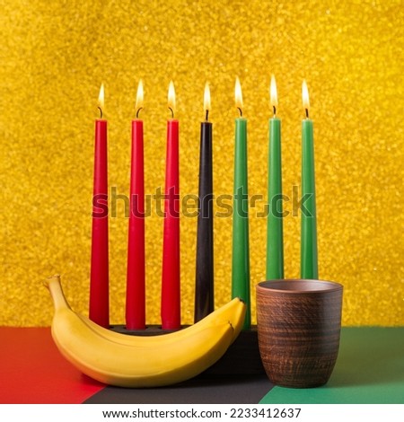 African Kwanzaa holiday concept with traditional lit candles, banana, bowl on symbolic background