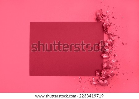 A blank sheet of paper and dried roses on a monochrome background. Top view, space for text. New 2023 trending PANTONE 18-1750 Viva Magenta color.