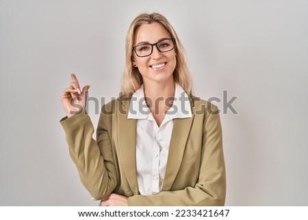 Young caucasian woman wearing glasses smiling happy pointing with hand and finger to the side 