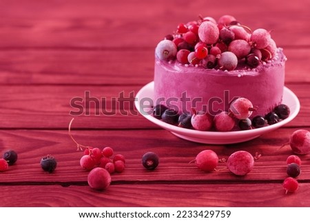 birthday cake with berries on wooden table in trendy color of year 2023