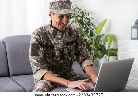 Young military soldier man portrait with laptop on background.