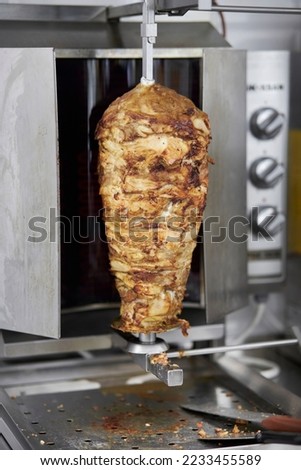 Shawarma. Close-up picture of shawarma.Traditional Turkish Meat Doner Kebab. Shawarma or gyros.Stainless steel machine slowly grills uneven layers of juicy chicken with fat. Shawarma meat cooking