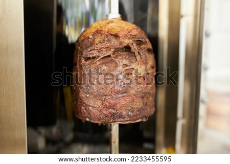 Shawarma. Close-up picture of shawarma.Traditional Turkish Meat Doner Kebab. Shawarma or gyros.Stainless steel machine slowly grills uneven layers of juicy chicken with fat. Shawarma meat cooking