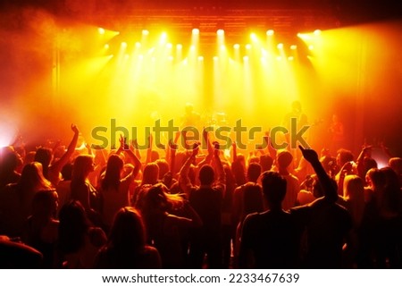 Rock hands, concert and music festival with crowd red disco lights for energy, dark and gen z psychedelic dance, celebration and party. Band, musician and group of people in the audience with freedom