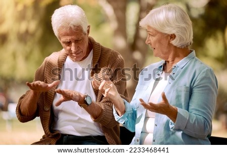 Senior couple, love and hands in sign language communication in nature, public park or garden. Retirement elderly, gesture or deaf disability in bonding date for man and woman in support conversation