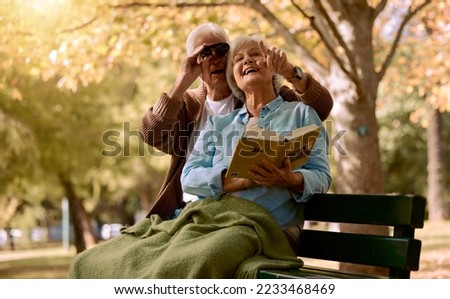 Park, bench and binoculars with a senior couple birdwatching together outdoor in nature during summer. Spring, love and book with a mature man and woman bonding while sitting in a garden for the view Royalty-Free Stock Photo #2233468469