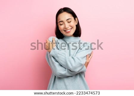I love myself! Portrait of self-satisfied egoistic woman embracing herself and smiling with pleasure, feeling self-pride. Studio shot isolated on pink background  Royalty-Free Stock Photo #2233474573