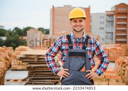 construction mason worker bricklayer installing red brick with trowel putty knife outdoors Royalty-Free Stock Photo #2233474853