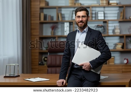 Portrait of successful and happy mature university teacher, man in business suit and academy director's office looking at camera and smiling. Royalty-Free Stock Photo #2233482923