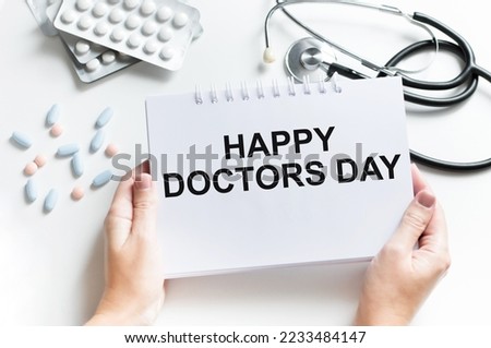 Creative Top view flat lay lightbox with the text happy doctor day. Doctor's Day concept, stethoscope with diagnosis of heart disease on blue background.