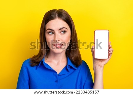 Portrait photo of young success entrepreneur business owner lady wear blue shirt look empty space phone menu app isolated on yellow color background