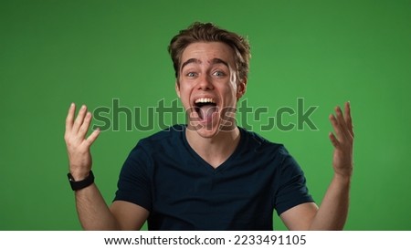 Portrait of excited, surprised smiling young hipster man 20s gives thumbs up smiling isolated on green screen background studio in slow motion