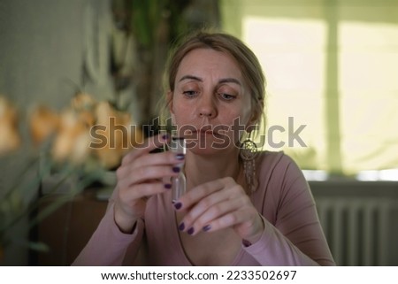 A pensive woman holds an hourglass and watches the time pass. Concept: business, management, deadline, climax, menopause, unstoppable time, time to get married, time to achieve something in life, agin Royalty-Free Stock Photo #2233502697
