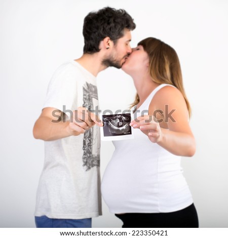 Happy couple expecting a baby and holding the ultrasound picture