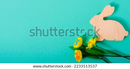Wooden bunny easter banner on green background flatlay