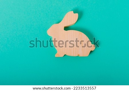 Wooden rabbit on a green background flatlay top view banner