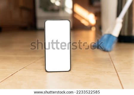 Home cleaning service concept, Mock up screen mobile phone in front of kitchen Floor. Copy space.
