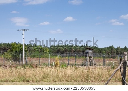 Border between Serbia and Hungary bewtween Kelebia and Tompa, with a watchtower and the Hungarian border fence. This wall was built in 2015 to stop the refugees passing through Serbia  Balkans Route. Royalty-Free Stock Photo #2233530853