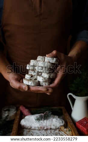 A male chef is holding a cake - stollen for a holiday. Christmas stollen pie cut into pieces
