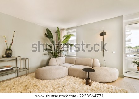 Contemporary minimalist style interior design of light studio apartment with wooden table and chairs in dining zone between open kitchen and living room with white walls and parquet floor Royalty-Free Stock Photo #2233564771