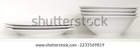 Stack of white plates on shelf
