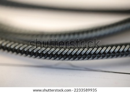 Carbon cable, close-drawn carbon cable on a white background. Selective focus, noise effect.