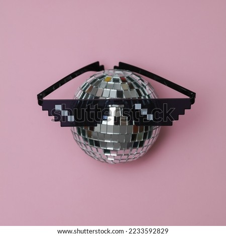 Disco ball with Pixelated 8 bit sunglasses on pink background