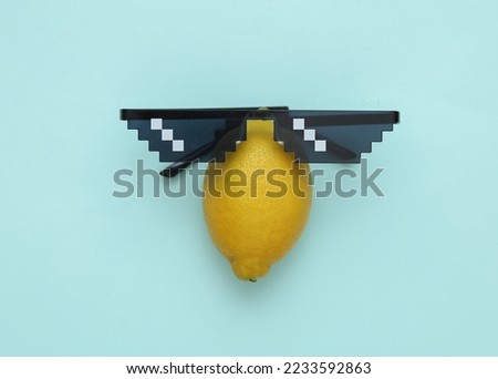 Pixelated 8 bit sunglasses with lemon on blue background. Minimal layout