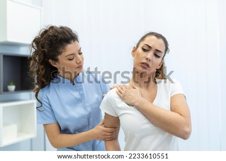 Woman doctor osteopath in medical uniform fixing woman patients shoulder and back joints in manual therapy clinic during visit. Professional osteopath during work with patient concept Royalty-Free Stock Photo #2233610551