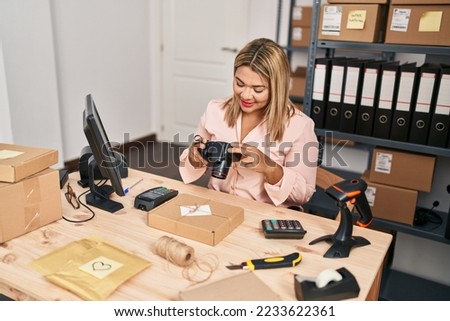 Young hispanic woman ecommerce business worker make photo to package at office