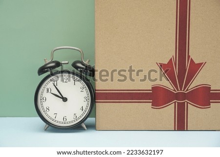 a gift box and alarm clock on the table