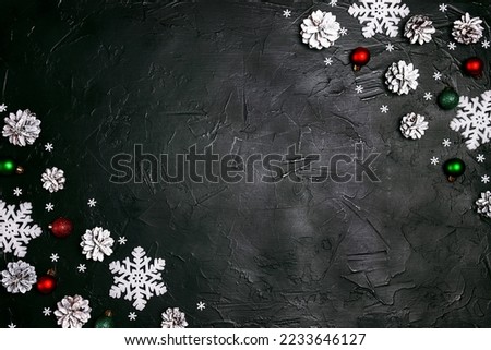 Festive frame withsnow painted cones and Christmas decorations on a black background. Christmas, New Year, winter concept with copy space.