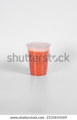 Carrot juice in a plastic cup at high res. image and isolated white.