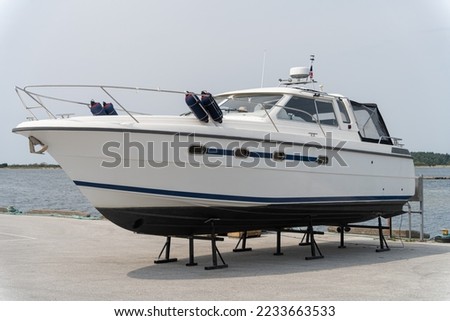 Boat on stand on the shore, close up on the part of the yacht, luxury ship, maintenance and parking place boat Royalty-Free Stock Photo #2233663533