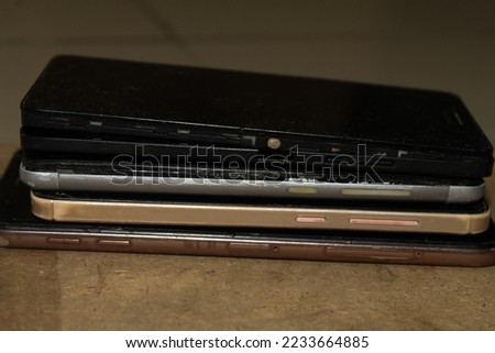 Piles of Modern Touch Screen Smartphone Phones with Damaged Screen Isolated in Natural Background
