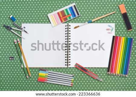 Sketch book and paint tools on table cloth