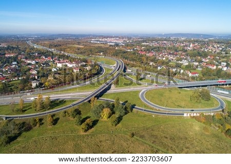Highway multilevel crossing. Interchange junction on A4 international highway with Zakopianka multilane road and railway. A part of freeway around Krakow, Poland. Aerial view. 