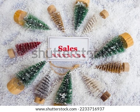 Christmas sales text written on paper note  with small pine trees round frame