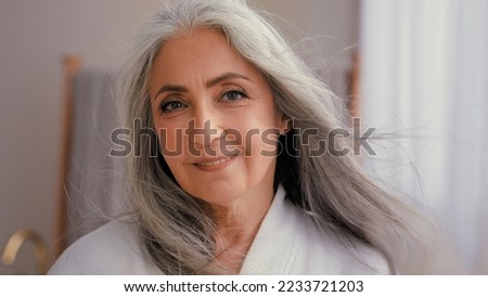 Headshot close up Caucasian gorgeous happy smiling middle-aged mature senior woman older 50s lady smile looking at camera pampering flying hair in wind waving healthy skin care haircare moisturizing Royalty-Free Stock Photo #2233721203