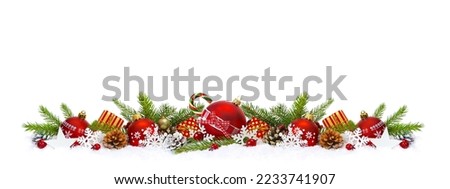 Christmas border composition of red christmas balls, Gift boxes, green fir branches pine cones and baubles in snow on white background.