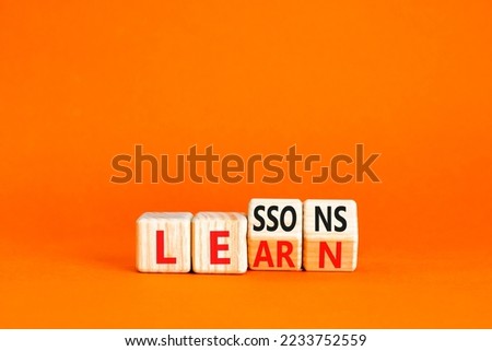 Lessons to learn symbol. Concept word Lessons learn on wooden cubes. Beautiful orange table orange background. Business education and lessons to learn concept. Copy space. Royalty-Free Stock Photo #2233752559