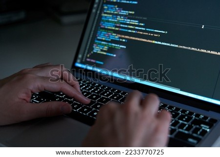 Programmer hands coding and developing software with html and javascript Royalty-Free Stock Photo #2233770725