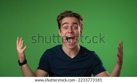 Portrait of excited, surprised smiling young hipster man 20s gives thumbs up smiling isolated on green screen background studio in slow motion