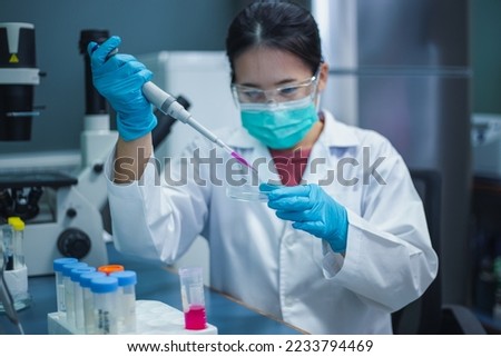 Scientist woman use micropipette with sample preparation from test tube of sample stock solution in the laboratory for bioassay of in vitro cells on glass Petri dishes. Medicinal, Medicine research.
