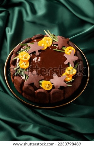 Christmas cake with chocolate and oranges on a green background