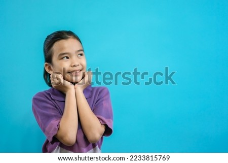 Children close up photo of cute and cheerful people, looking up and smile on blue pastel background, cute kids adorable curious and smart gril, create new idea show wow emotion on copy space isolated 
