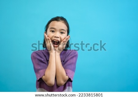 Children close up photo of cute and cheerful people, looking and smile on blue pastel background, cute kids adorable curious and smart girl, create new idea show wow emotion copy space