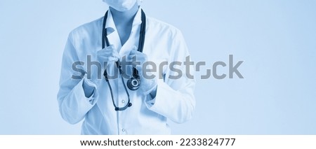 Young female doctor holding stethoscope hanging on her neck, studio shot over white background with copy space