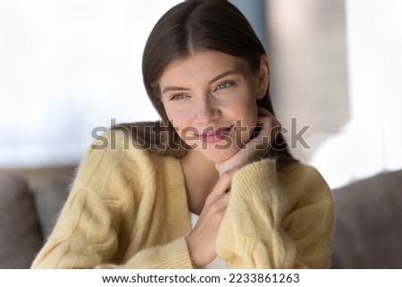 Positive dreamy pretty young woman wearing sift warm sweater, enjoying leisure, touching chin, looking away, thinking over future plans, dreaming, smiling, relaxing at cozy home Royalty-Free Stock Photo #2233861263